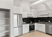 Thumbnail 34 of 55 - A modern kitchen with stainless steel appliances and white cabinetry.