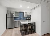 Thumbnail 48 of 61 - a kitchen with a island and a stainless steel refrigerator at AVIA Lofts on Liberty Ridge, Jacksonville, FL