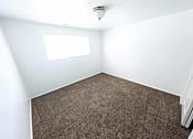 Thumbnail 8 of 14 - A room with a carpeted floor and a window.
