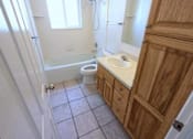 Thumbnail 9 of 14 - A bathroom with a toilet, sink, and mirror.