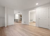 Thumbnail 88 of 92 - A room with white walls and wooden flooring with a table and chairs in the background at AVIA Lofts on Parkway Apartments, Vancouver