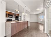 Thumbnail 55 of 71 - a kitchen and living room with hardwood floors and a sliding glass door at Wilmington Flats Apartments, Salt Lake City, UT