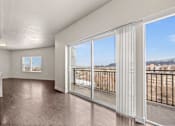 Thumbnail 57 of 71 - a living room with a large window and a balcony at Wilmington Flats Apartments, Salt Lake City, Utah