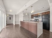 Thumbnail 56 of 71 - a kitchen with an island and a black refrigerator at Wilmington Flats Apartments, Salt Lake City, Utah