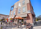 Thumbnail 6 of 50 - a brick building with tables outside of it at The View on 20th, Ogden, Utah