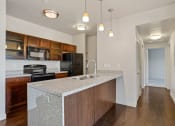 Thumbnail 49 of 71 - a kitchen with an island with a sink and a stove at Wilmington Flats Apartments, Salt Lake City, UT