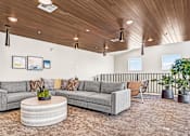 Thumbnail 17 of 144 - A living room with a grey sofa, a round coffee table, and a wooden ceiling.