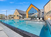 Thumbnail 6 of 144 - A large swimming pool with a wooden building in the background.