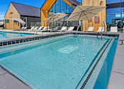 Thumbnail 7 of 144 - A large swimming pool with a wooden building in the background.