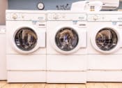 Thumbnail 22 of 51 - a row of white washing machines in a laundry room