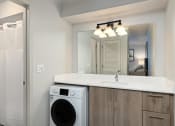 Thumbnail 30 of 50 - a bathroom with a washer and a sink