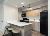Thumbnail 19 of 50 - a kitchen with a white counter top and wooden cabinets