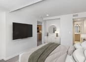 Thumbnail 24 of 50 - a bedroom with a large bed and a tv on the wall