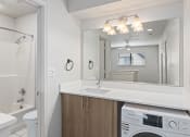 Thumbnail 44 of 50 - a white laundry room with a sink and a washing machine