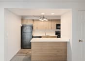 Thumbnail 47 of 50 - a renovated kitchen with wood cabinets and a black refrigerator