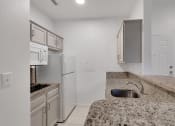 Thumbnail 34 of 51 - a kitchen with granite counter tops and white appliances