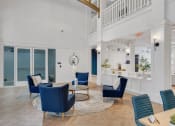 Thumbnail 7 of 51 - a living room with blue chairs and a table with chairs