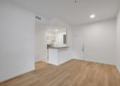 Thumbnail 36 of 51 - a living room and kitchen with white walls and wood flooring