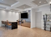 Thumbnail 11 of 51 - a living room with a bar and a tv on the wall