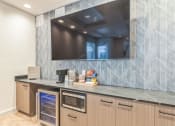 Thumbnail 12 of 51 - a kitchen with a large tv on the wall and a counter with a dishwasher
