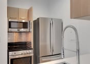 Thumbnail 25 of 51 - a kitchen with stainless steel appliances and a refrigerator