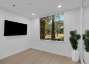 Thumbnail 21 of 51 - a living room with a large window and a tv on the wall