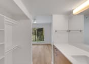 Thumbnail 50 of 51 - the living room and kitchen of an apartment with white cabinets and a window