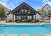 Thumbnail 1 of 56 - a pool area with a swimming pool and a house in the background