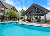 Thumbnail 5 of 56 - A swimming pool in front of a building with a glass pavilion.