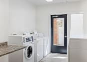 Thumbnail 23 of 56 - a laundry room with washers and dryers