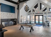 Thumbnail 20 of 56 - a pool table in the clubhouse at the bradley braddock road station apartments