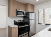 Thumbnail 40 of 56 - a small kitchen with white countertops and wooden cabinets