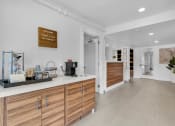 Thumbnail 19 of 61 - a kitchen with white walls and wooden cabinets and a white counter top at AVIA Lofts on Liberty Ridge, Jacksonville, FL
