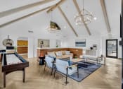 Thumbnail 18 of 61 - a living room with furniture and a pool table at AVIA Lofts on Liberty Ridge, Jacksonville, FL, 32256