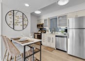 Thumbnail 3 of 61 - a kitchen with stainless steel appliances and a table with chairs at AVIA Lofts on Liberty Ridge, Jacksonville, FL