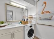 Thumbnail 11 of 61 - a laundry room with a sink and a washing machine and a mirror and a tub at AVIA Lofts on Liberty Ridge, Florida, 32256