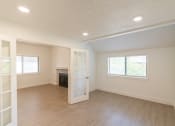Thumbnail 29 of 34 - an empty living room with a fireplace and a white door
