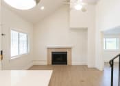 Thumbnail 24 of 34 - an empty living room with a fireplace and a ceiling fan