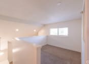 Thumbnail 33 of 34 - the living room and dining room in a renovated home with white walls and carpet