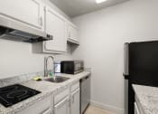 Thumbnail 8 of 45 - the kitchen of our studio apartment atrium with granite counter tops and white cabinets