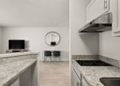 Thumbnail 10 of 45 - a kitchen with granite counter tops and a living room with a tv