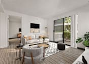 Thumbnail 9 of 92 - A modern living room with a grey sofa, a coffee table, and a large window.
