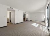 Thumbnail 52 of 92 - the living room and dining room of an apartment with white walls and a striped carpet at AVIA Lofts on Parkway Apartments, Vancouver