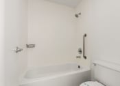 Thumbnail 50 of 92 - a white bathroom with a tub and a toilet at AVIA Lofts on Parkway Apartments, Vancouver, WA