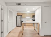 Thumbnail 39 of 92 - a kitchen with a large island and a stainless steel refrigerator at AVIA Lofts on Parkway Apartments, Washington, 98662