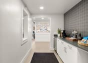 Thumbnail 6 of 92 - a kitchen with white cabinets and a counter top and a door to a store at AVIA Lofts on Parkway Apartments, Vancouver, 98662