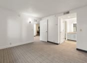 Thumbnail 43 of 92 - the living room and kitchen of an apartment with a carpeted floor and white walls at AVIA Lofts on Parkway Apartments, Vancouver, Washington