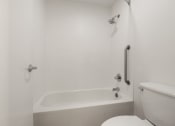 Thumbnail 56 of 92 - a white bathroom with a tub and a toilet at AVIA Lofts on Parkway Apartments, Washington, 98662