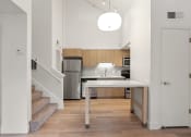 Thumbnail 57 of 92 - a kitchen with a white table and a stainless steel refrigerator at AVIA Lofts on Parkway Apartments, Washington