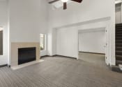Thumbnail 63 of 92 - an empty living room with a fireplace and a ceiling fan at AVIA Lofts on Parkway Apartments, Vancouver, WA